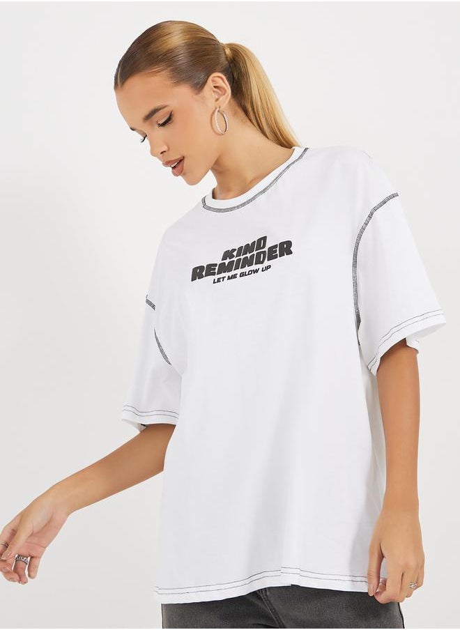 Styli - Oversized Slogan Print Round Neck T-Shirt with Contrast Stitch - Image 1