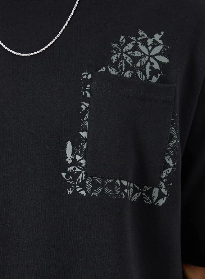 ستايلي تيشيرت انترلوك واسع بطبعة على الجيب