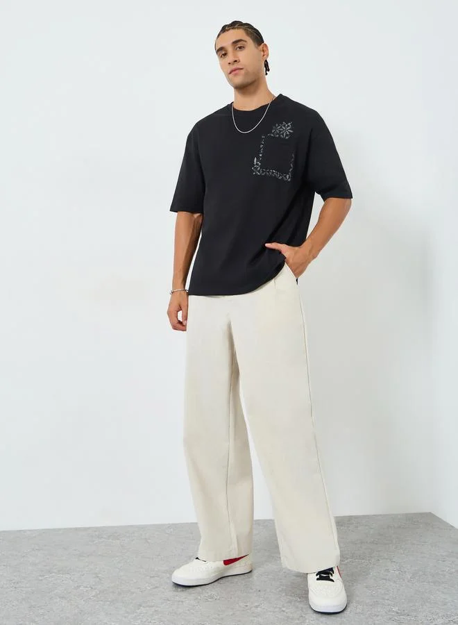 ستايلي تيشيرت انترلوك واسع بطبعة على الجيب