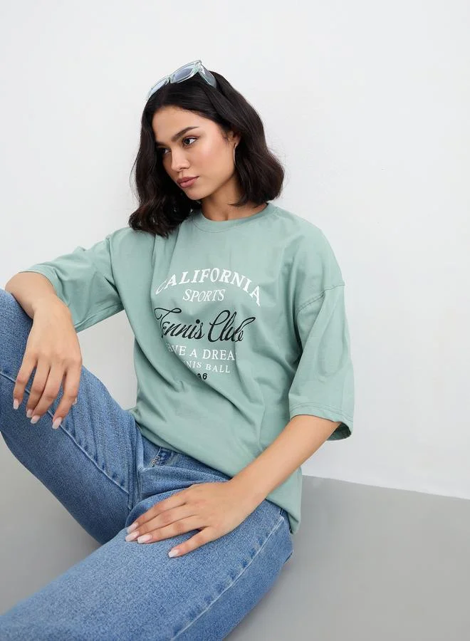 Styli Styli Women Green Slogan Print Dropped Shoulder Oversized T-Shirt