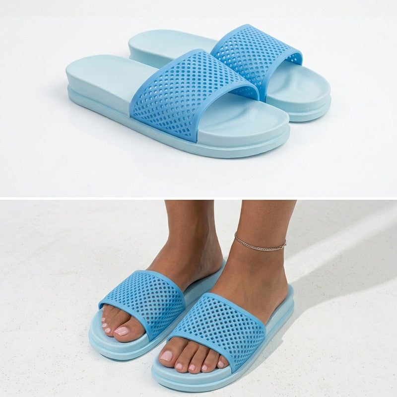 An elegant women's slide sandal featuring a classic two-tone color contrast. The footbed and outsole share a soft, subtle light shade, while the wide upper strap has a contrasting clean, bright light hue. This strap boasts a distinctive perforated mesh pattern for optimal breathability and airflow. Crafted from lightweight, flexible, and shock-absorbing EVA material, it offers all-day comfort.