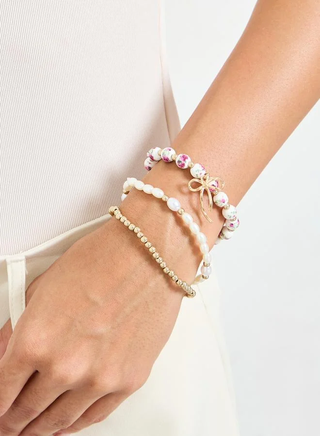 ستايلي Pack of 3 - Gold Tone and Pearl Beaded Bracelets with Bow Charm