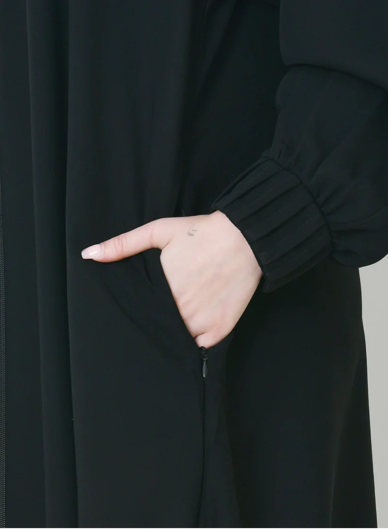 HAWRAA ABAYA Black zippered abaya with narrow pleated sleeves and hidden zippered pockets