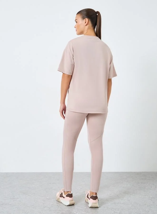 ستايلي اكتيف Gymspire Edition - Label and Tab Dropped Shoulder Short Sleeve Top with Text Detail