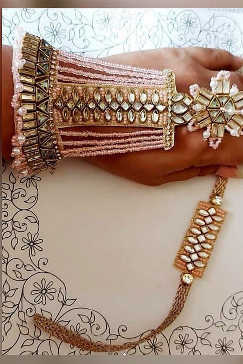 Bhai bhabhi Rakhi Pair 
Bhabhi Hathful style Rakhi
Designed with Peach color pearls & Kundan work.Unique design in Hathful pattern.