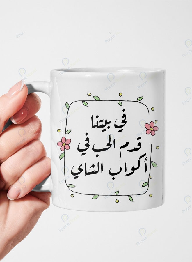 كوب من السيراميك مطبوع عليه عبارة في بيتنا قدم الحب في أكواب الشاي ويتميز بمقبض مريح