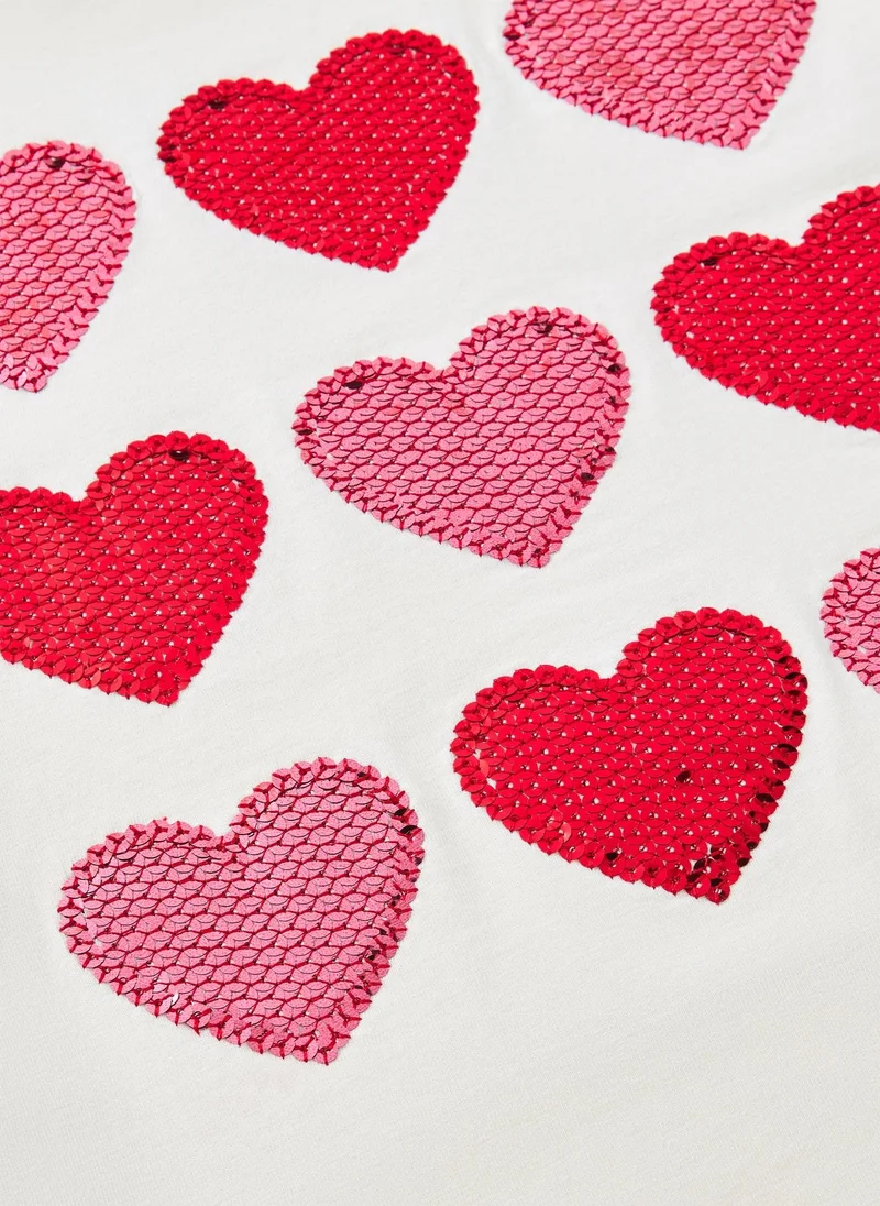 ماتلان تيشيرت بناتي باللون الكريمي مزين بقلوب لامعة