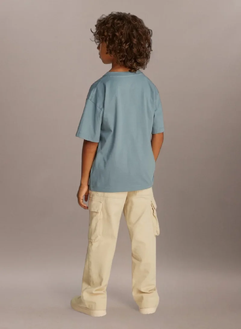 كالفن كلاين جينز تيشيرت بقصّة مريحة مزين بالشعار