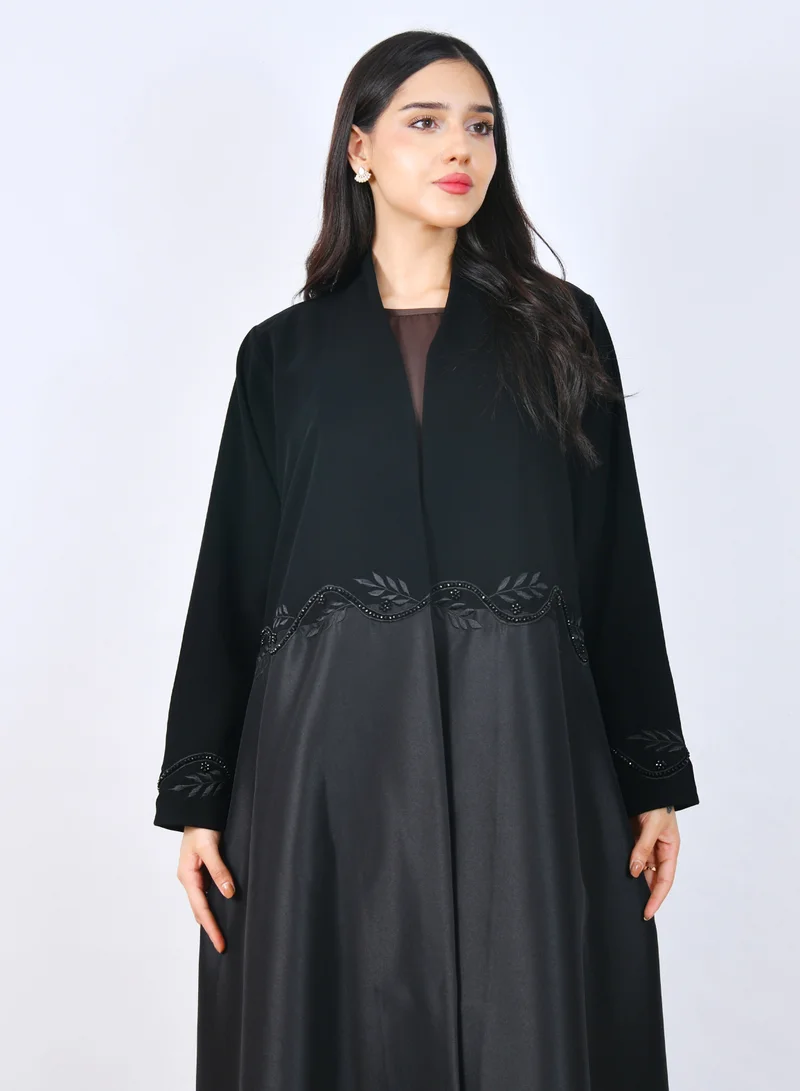 HAWRAA ABAYA Elegant abaya with embroidered details in the form of overlapping leaves at the waist and sleeves.