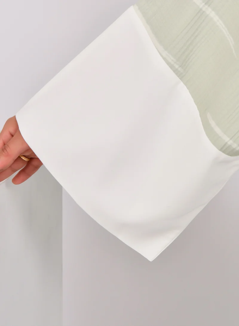 HAWRAA ABAYA Light green wide sleeve abaya with white stripes and a white dress