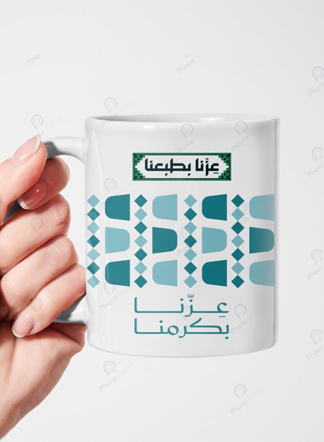 كوب من السيراميك مطبوع بعبارة عزنا بطبعنا وعزنا بكرمنا ومقبض مريح