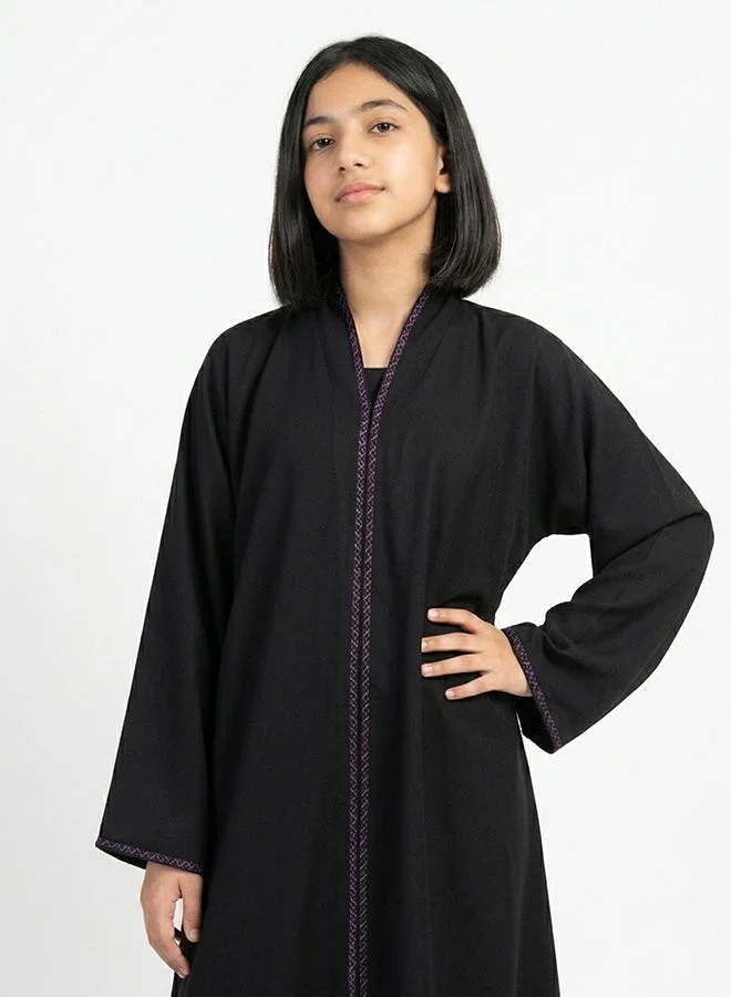 HAWRAA ABAYA Black girls’ wrap abaya featuring delicate purple embroidery along the edges