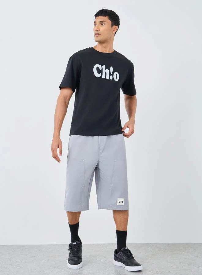 ستايلي تيشيرت أوفر سايز بياقة دائرية وطبعة شعار ستايلي