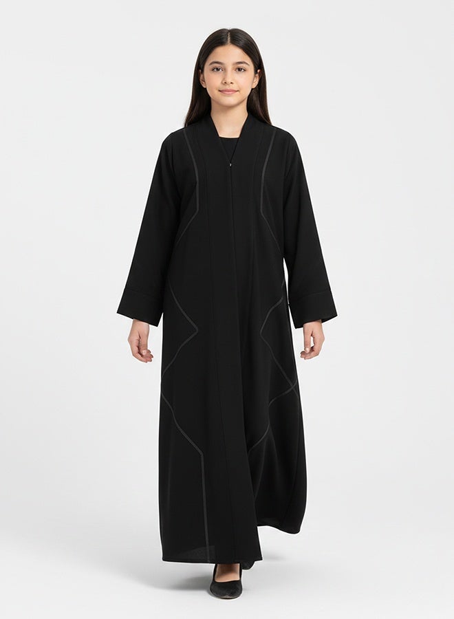 HAWRAA ABAYA Black girls’ abaya with a snap-button closure, adorned with braided trim, featuring a flexible design - Image 4