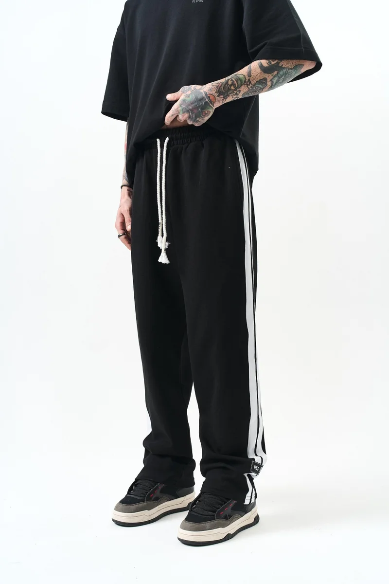 ريسباير بنطلون رياضي رجالي واسع (Baggy) متداخل (Interlock) بتفاصيل شريط، أسود