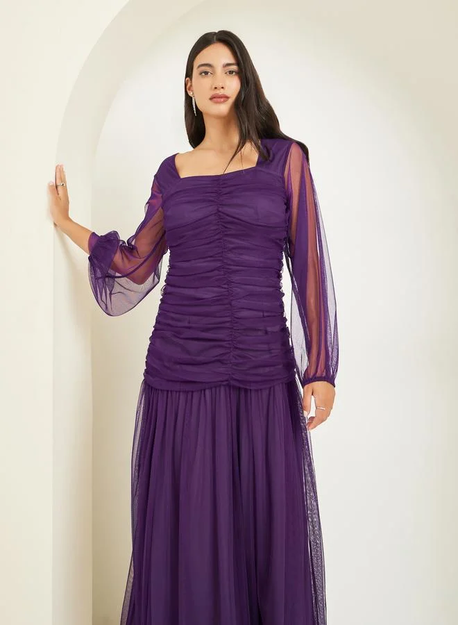 ستايلي فستان طويل بتفاصيل مُجمعة شبك وأكمام طويلة