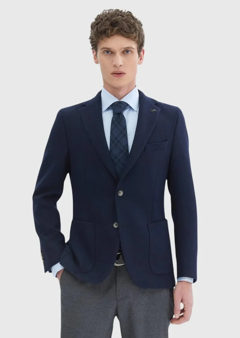 رامسي قميص أزرق داكن بنقوش، بقصة ضيقة عند الكتفين، وجاكيت من مزيج الصوف