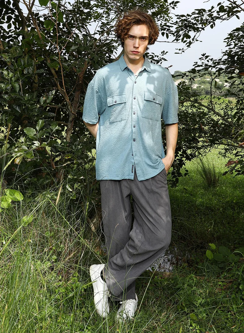 Campus Sutra Campus Sutra Men's Sage Green Tactile-Utility Oversized Shirt For Casual Wear | Spread Collar | Short Regular Sleeves | Button Closure | Oversized Shirt Crafted With Comfort Fit For Everyday Wear