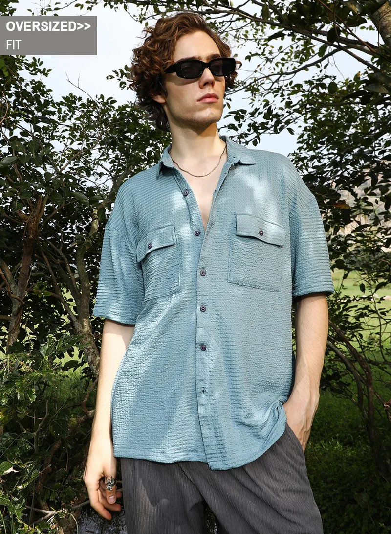 Campus Sutra Campus Sutra Men's Sage Green Tactile-Utility Oversized Shirt For Casual Wear | Spread Collar | Short Regular Sleeves | Button Closure | Oversized Shirt Crafted With Comfort Fit For Everyday Wear