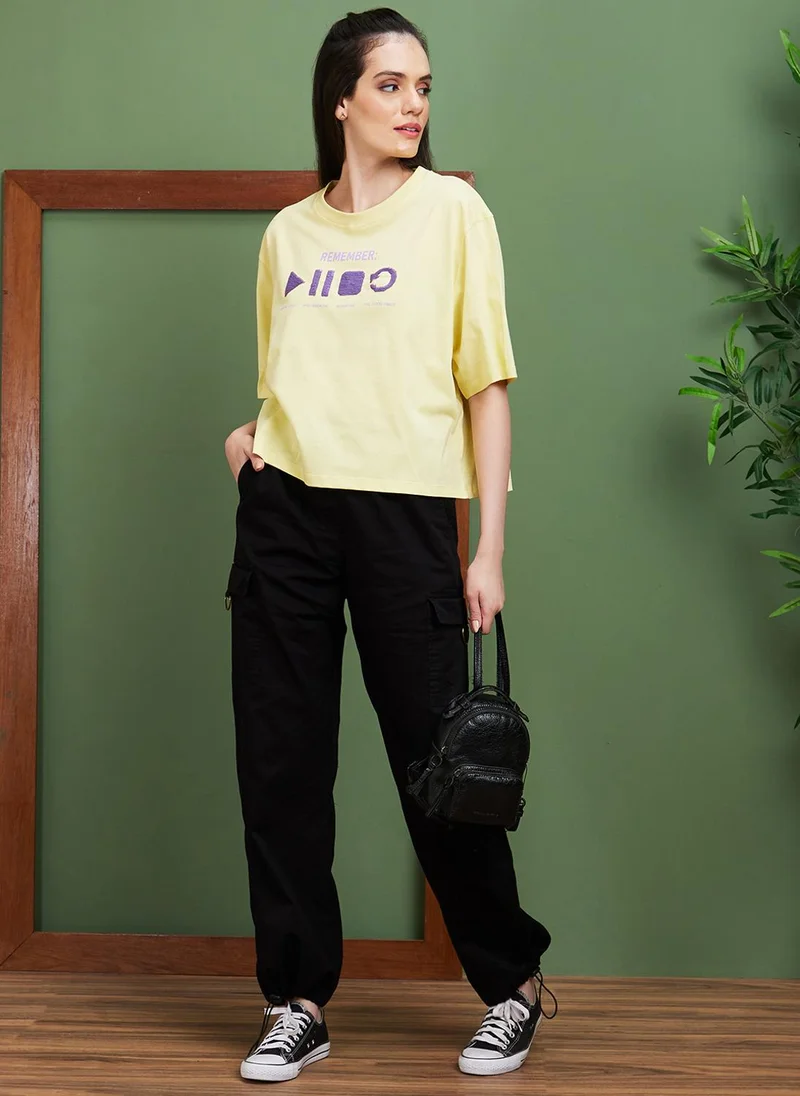 جلو باص تيشيرت نسائي قطن أصفر بياقة دائرية وقصة واسعة بطباعة حروف