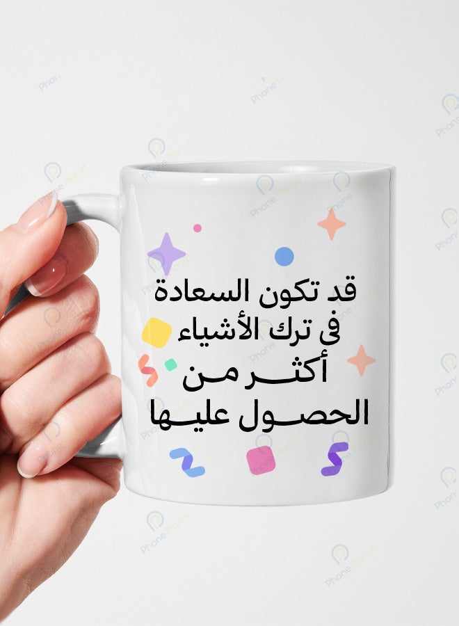 A ceramic mug printed with the phrase Happiness may lie in letting go and featuring a comfortable handle