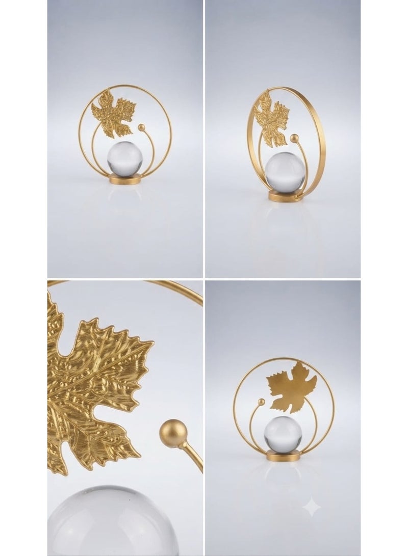 A decorative gold metal ornament with a circular design featuring a leaf and a clear crystal ball - a modern and elegant decoration for tables and shelves. - Image 1