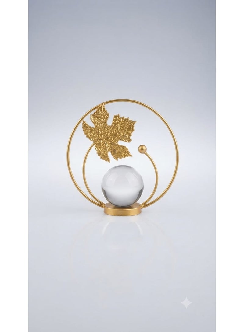 A decorative gold metal ornament with a circular design featuring a leaf and a clear crystal ball - a modern and elegant decoration for tables and shelves. - Image 4