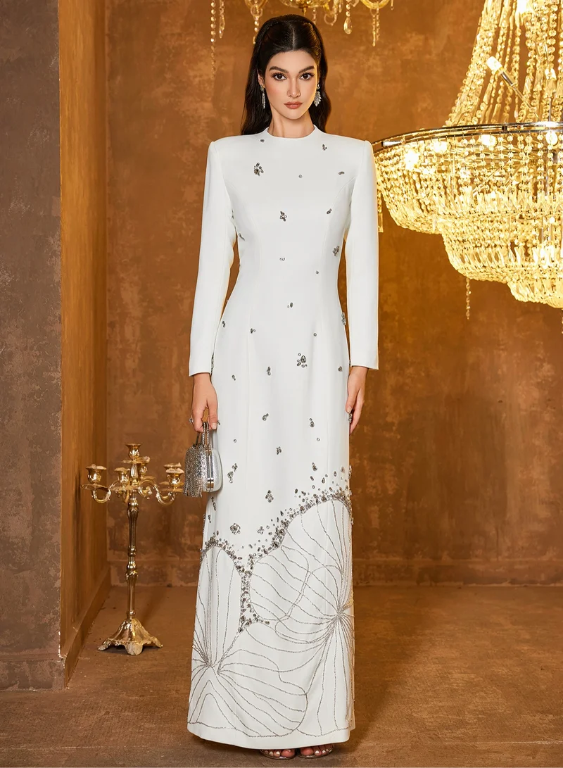 Madam Uniq Long white dress with long sleeves adorned with heavy sewing, beads and gemstones