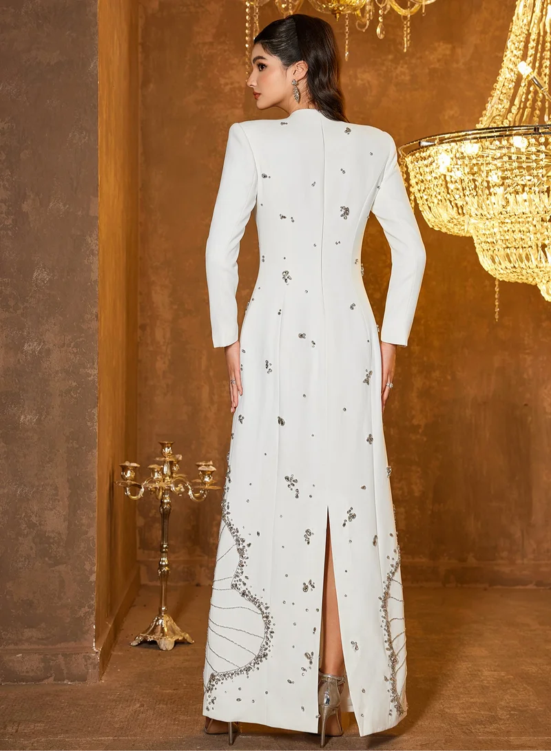 Madam Uniq Long white dress with long sleeves adorned with heavy sewing, beads and gemstones