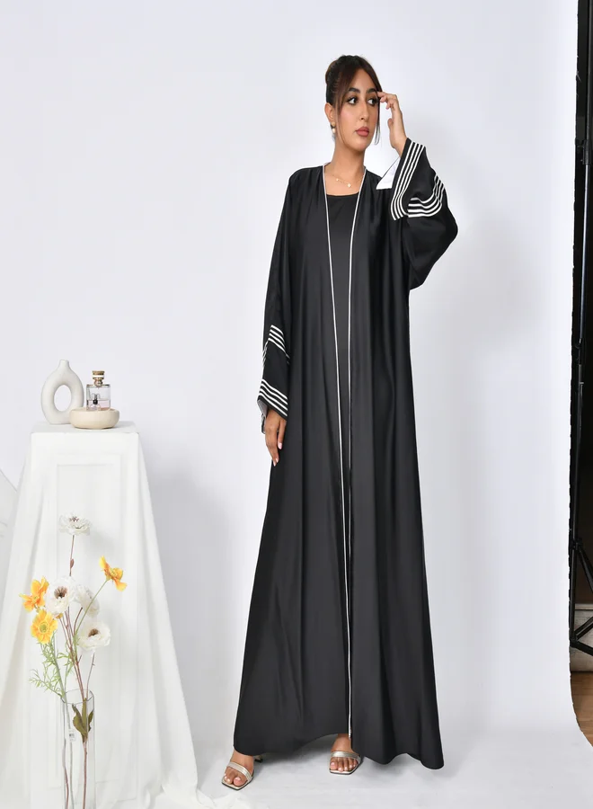 HAWRAA ABAYA Black abaya with wide sleeves decorated with white ribbons