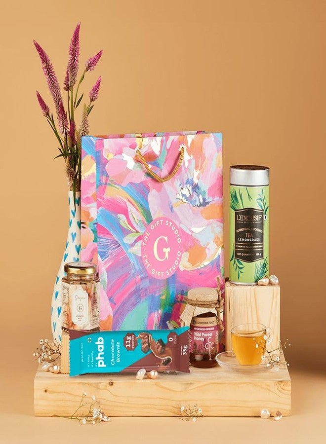 THE GIFT STUDIO.COM Wholesome Indulgence Gift Hamper | Healthy Snacks, Lemongrass Tea & Honey | Guilt-Free Gifting in Floral Bag - Image 1