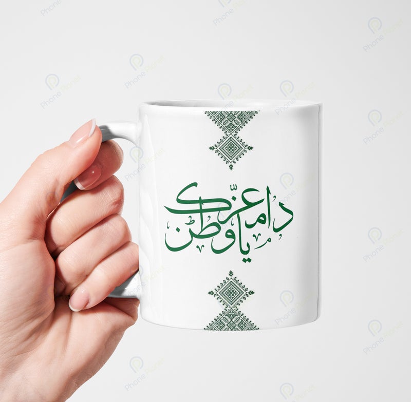A ceramic mug printed with the phrase May your glory last O homeland and featuring a comfortable handle
