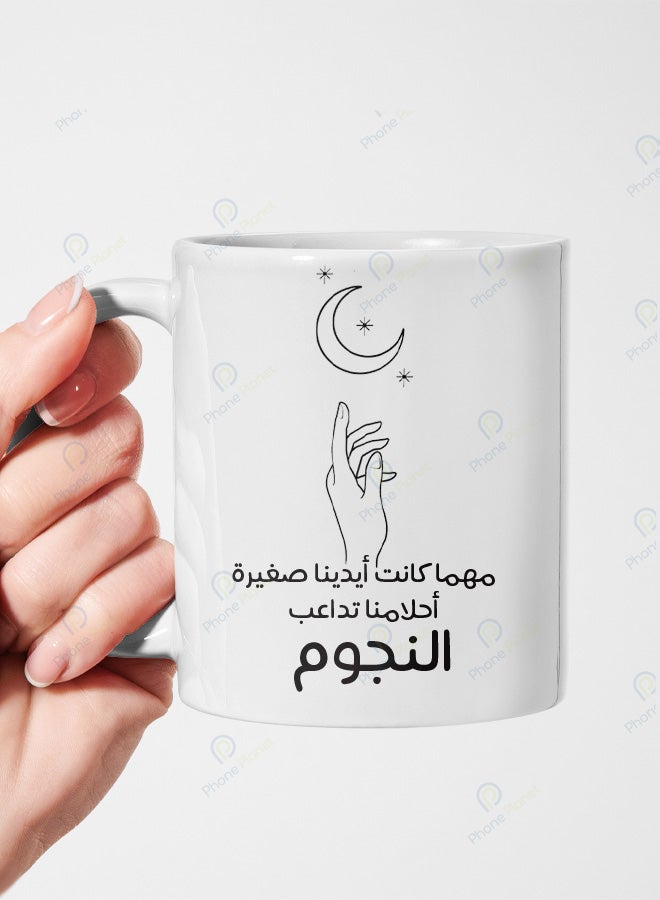 A ceramic mug printed with the phrase No matter how small our hands are our dreams reach for the stars featuring a comfortable handle