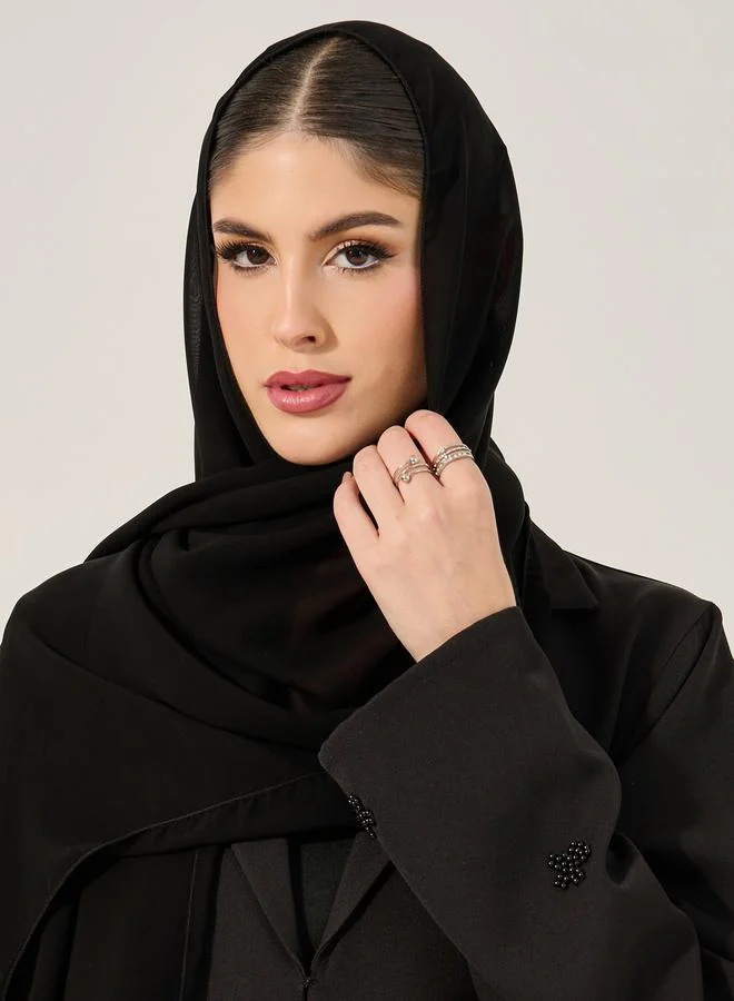 ستايلي عباية مزينة بياقة مشقوقة مع حجاب