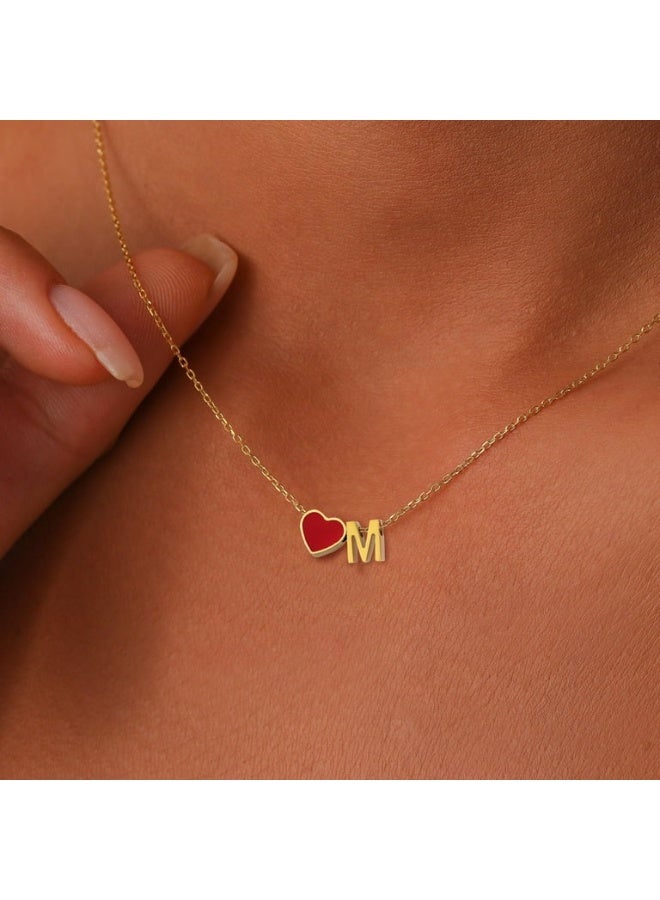Luxuria A gold-colored necklace featuring an "M" shaped pendant with a small red heart-shaped charm. - Image 2