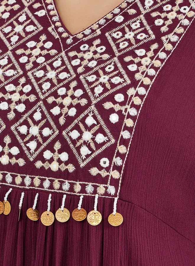 ستايلي جلابية مطرزة بنقوش مع تفاصيل شرابة عملات معدنية