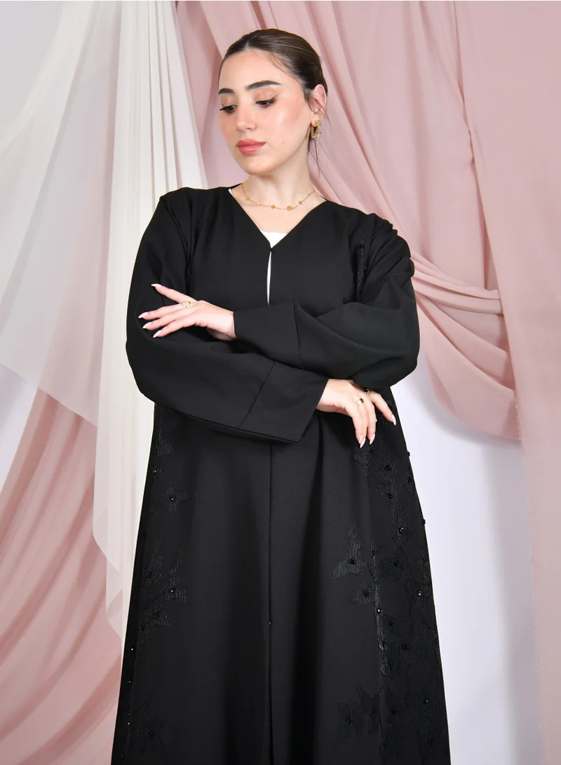 HAWRAA ABAYA Black quarter-cloche abaya with closed buttons, decorated with organza thread embroidery and beading