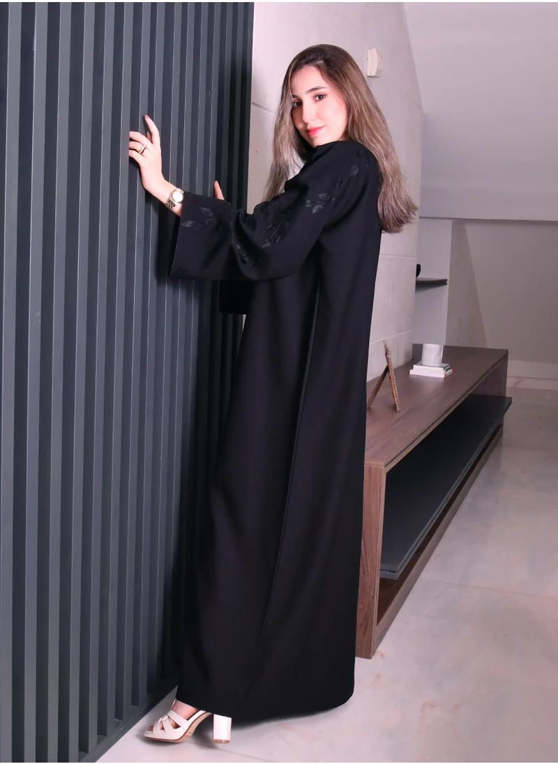 HAWRAA ABAYA A closed abaya with tree embroidery on the wide sleeves