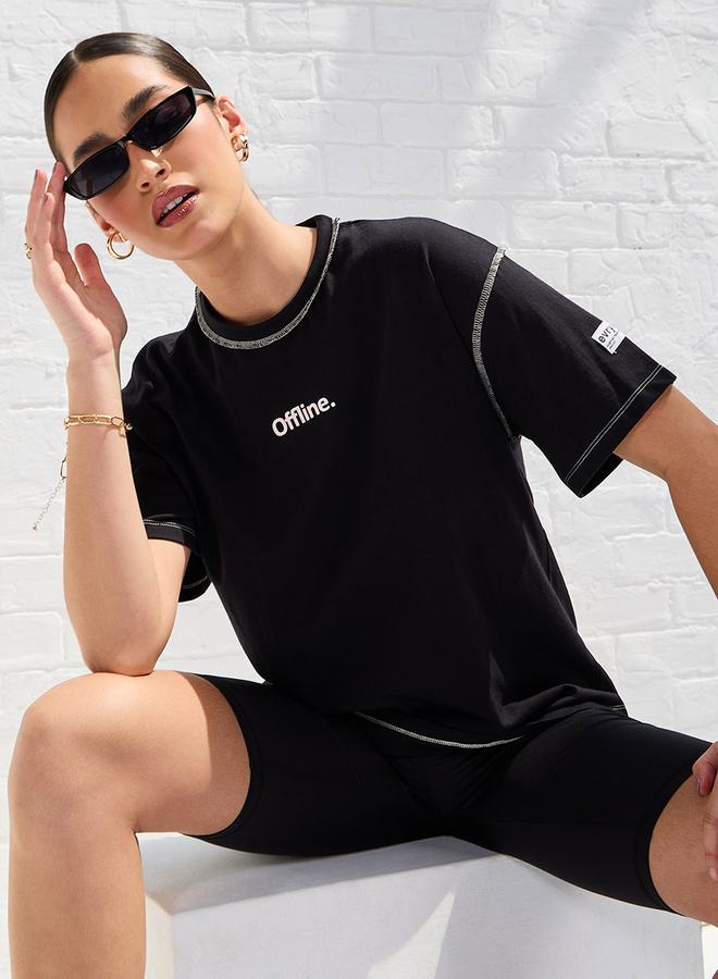 ستايلي تيشيرت كبير بكتف ساقط وشعار مع درزات ظاهرة - Image 1