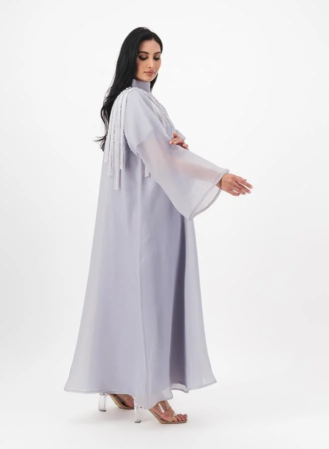 ميم باي ماريا Closed abaya with hanging tassel details on front and back. Comes with inner