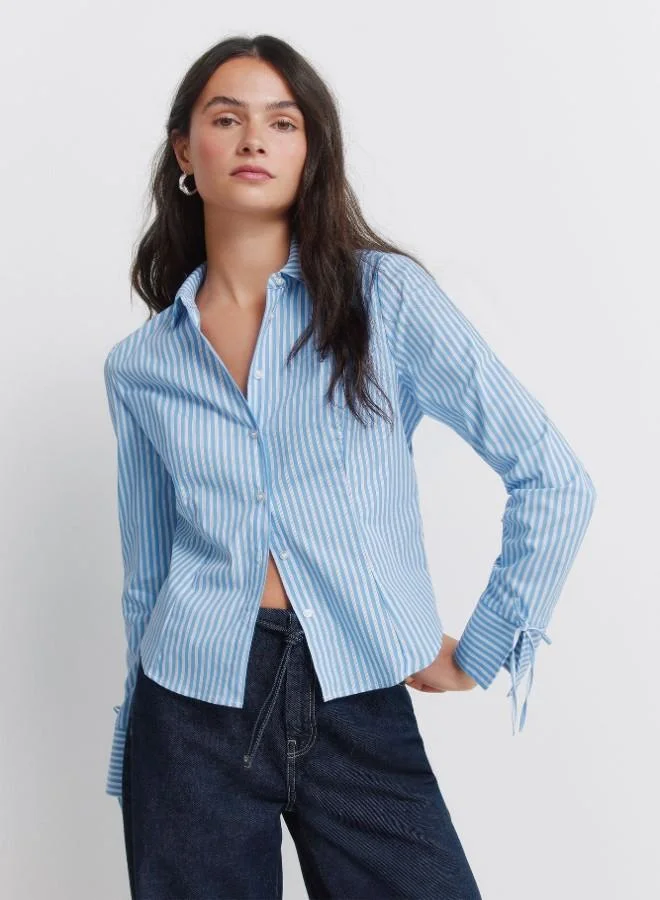 Fitted cotton shirt, with a shirt collar, with buttons on the front and cuffs.