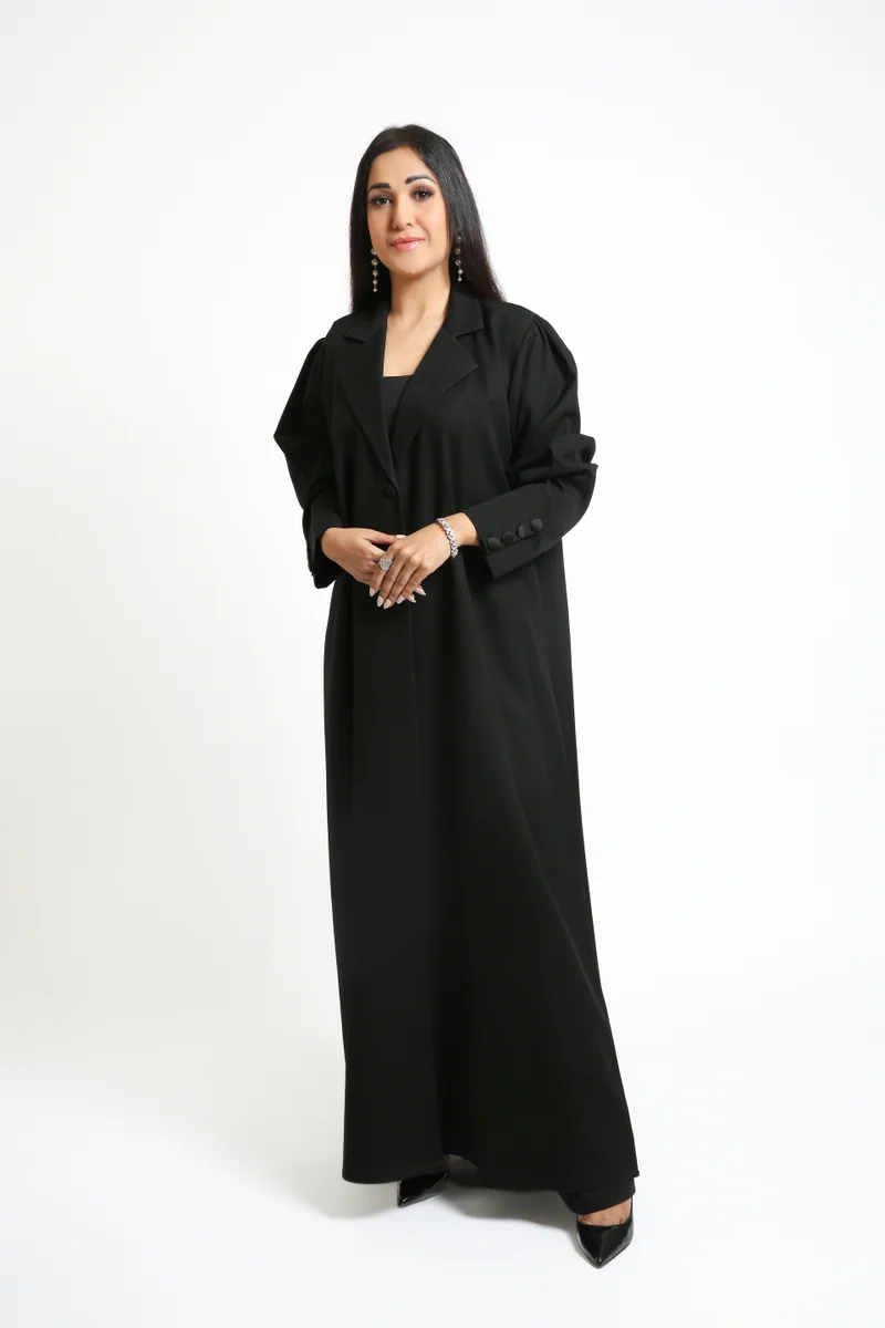 Nikias A sleek Black Crepe Overlap Abaya designed with signature loop accents along the front and sleeves