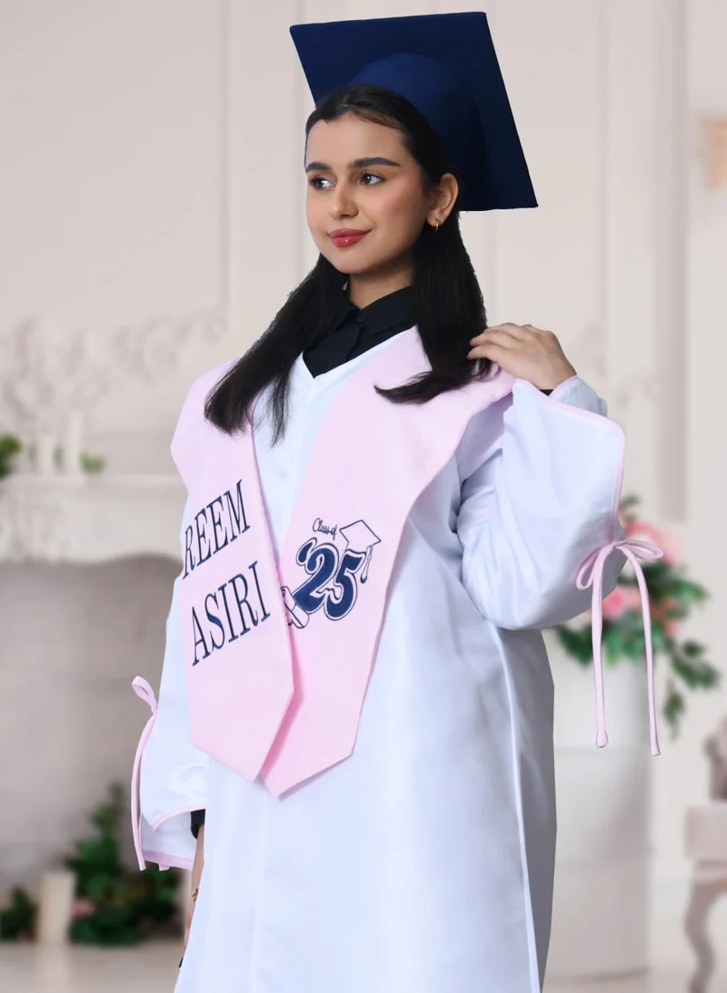 HAWRAA ABAYA Graduation uniform: a bright white abaya with a wide, open sleeve decorated with a bow, with a scarf and a plain cap in pink