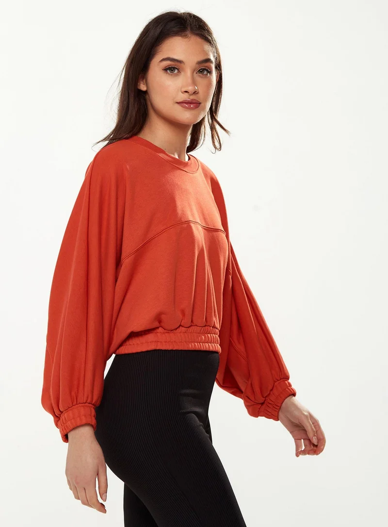 Liquorish Cropped Sweatshirt in Orange
