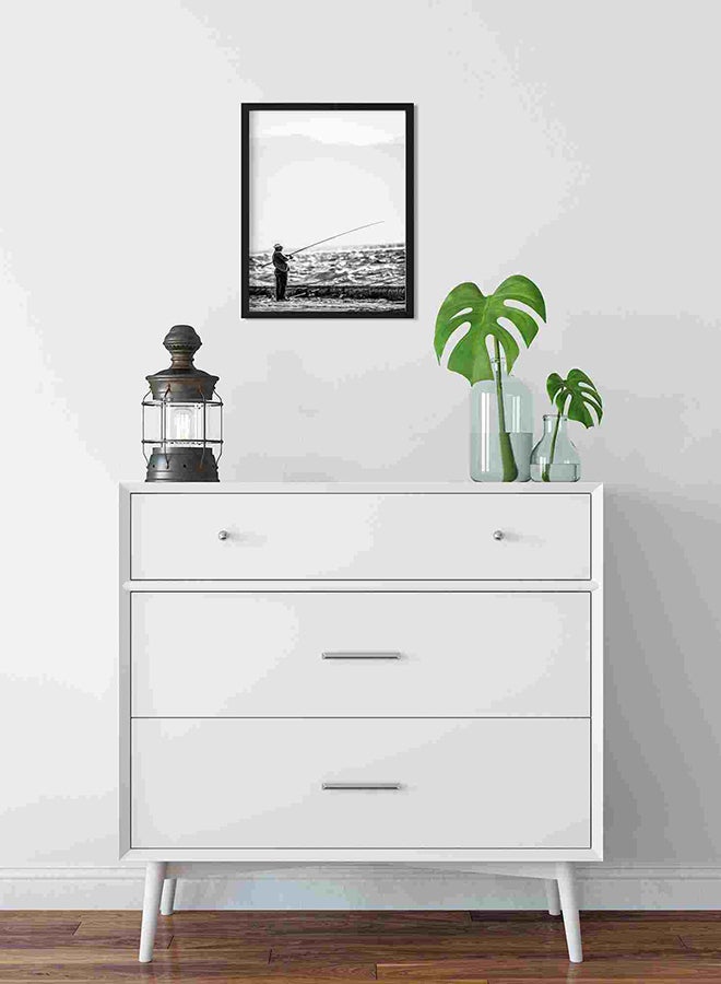 لوحة فنية لديكور الحائط برسمة رجل يقف بالقرب من شاطئ البحر حاملاً صنارة صيد متعدد الألوان 32x22x2سم - Image 2