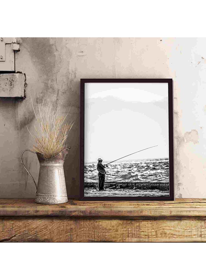 لوحة فنية لديكور الحائط برسمة رجل يقف بالقرب من شاطئ البحر حاملاً صنارة صيد متعدد الألوان 32x22x2سم - Image 5