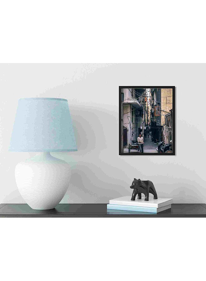 لوحة فنية لديكور الحائط برسمة رجل يقف بجوار دراجة ثلاثية العجلات متعدد الألوان 32x22x2سم - Image 3