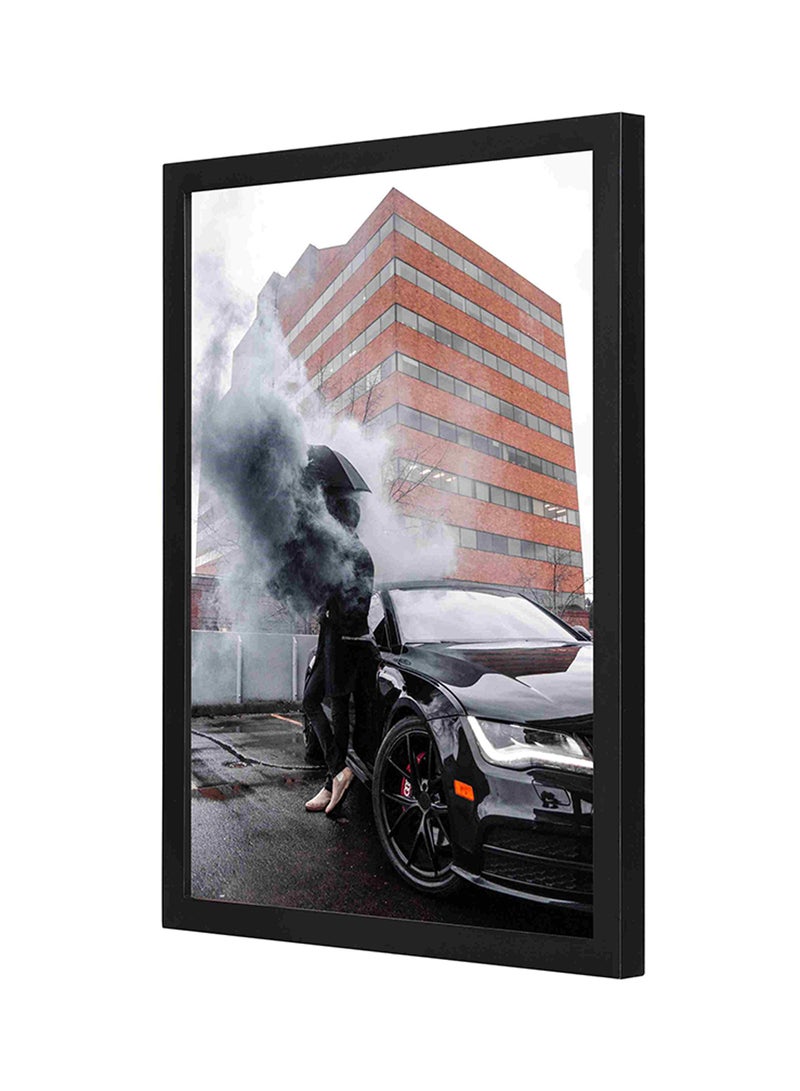 لوحة فنية لديكور الحائط بإطار خشبي تصوِّر رجلاً يتكئ على سيارة أسود/ أبيض 33x43سم - Image 1