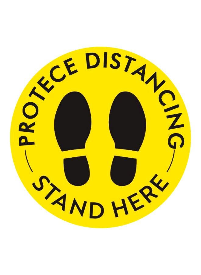 لافتة أرضية بطبعة عبارة "Stand Here" للحفاظ على التباعد الإجتماعي أصفر/أسود 27.94سم  - Image 1
