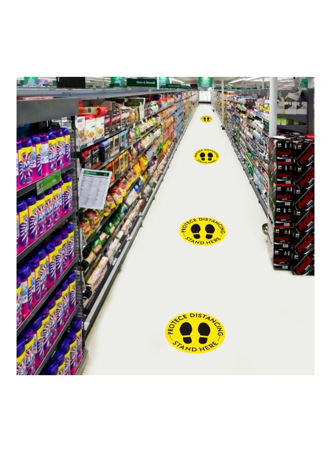 لافتة أرضية بطبعة عبارة "Stand Here" للحفاظ على التباعد الإجتماعي أصفر/أسود 27.94سم  - Image 3